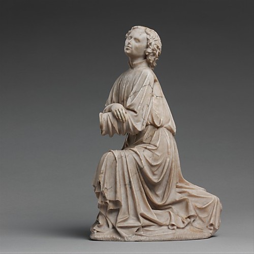 An alabaster statue of a kneeling angel, from c. 1430-40. The statue was made in Burgundy and stands