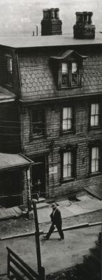 liquidnight:  W. Eugene Smith Untitled (Lone figure walking past tenements) Pittsburgh, 1955-56 From W. Eugene Smith: Photographs 1934-1975 