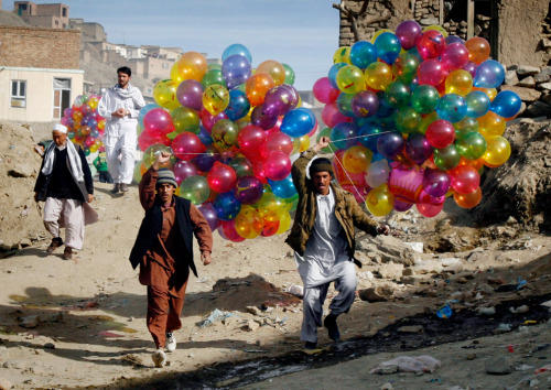 politics-war:politics-war: Afghans carry balloons to sell, as they walk toward the Sakhi Shrine for 