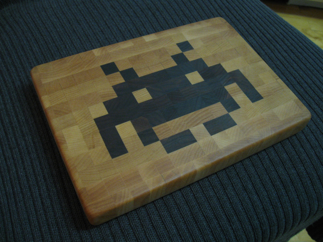 pacalin:
“ Space Invader Cheese Board - by David Abramson
Made from birch and black walnut, and finished with food-grade mineral oil and beeswax.
9 1/4” x 6 5/8” and 1 1/8” thick. Cushion shaped (curved edges).
Available for $60 USD at Etsy.
”