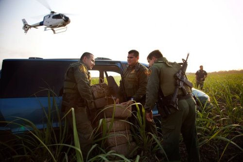 politics-war:Border Patrol officers inspect the inside of a van filled with roughly 800 pounds of ma