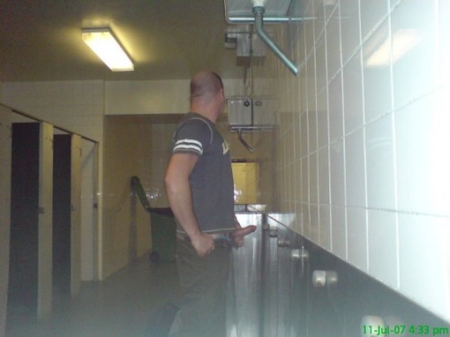 Guy jerking his cock at a urinal at a highway rest stop.  