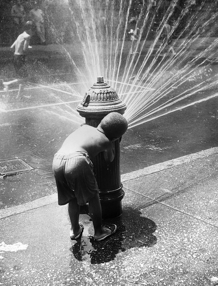 luzfosca:  New York children cooling off under the spray of a fire hydrant during