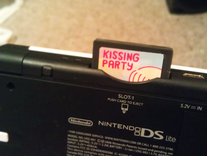 What’s that cartridge peeking out of that DS? (click for a larger image). Why, it’s Kissing Party, one of four designs from our $5 sticker pack for DS/3DS games!
Tiny Cartridge reader Phillis took this shot after replacing the “lame” label on her M3i...