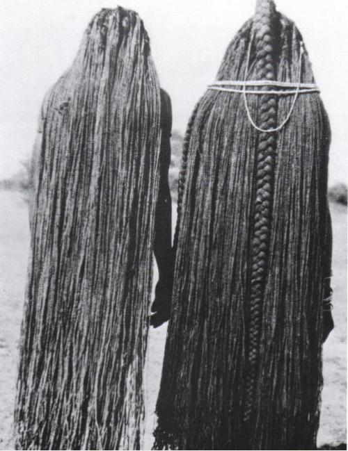 Two women whose braids have been lengthened to their ankles through the use of sinew (eefipa) extens