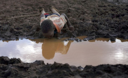 politics-war:  A child drinking from a puddle in the village of Duba Bule, outskirts of Moyale, along the Somali and Oromia regions of Ethiopia. 