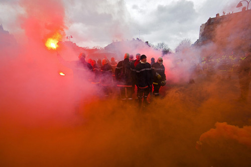 psychedelicmandala: February 16th, 2012 in Paris, France: Firefighters wave flares and spray down po