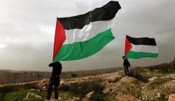 picturesoftheday:  Palestinian activists held Palestinian national flags in front of the  separation barrier in the West Bank village of Billin on Friday, during a  protest calling for the release of the Palestinian prisoner Khader  Adnan. 