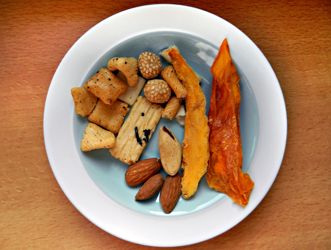 Mid-morning snack - dried mango, Japanese rice crackers, 3 almonds and a Brazil nut.