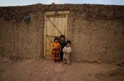 fungazi-deactivated20120817:  Afghan refugee children stand at the main gate of their muddy house at a slum on the outskirts of Islamabad, Jan. 4, 2012. (Anjum Naveed/Associated Press) 