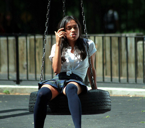 Rosario Dawson smoking in a schoolgirl outfit.