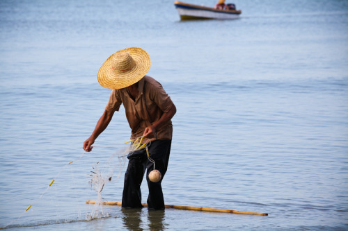 A fisherman laying down nets in Sanya Bay (South China Sea). 