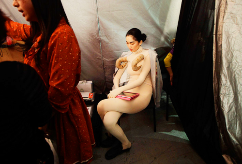 A model waits backstage before a show at China Fashion Week, Beijing, China.