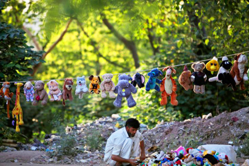 A Pakistani vendor displays his dolls on a roadside as he waits for customers on the outskirts of Is