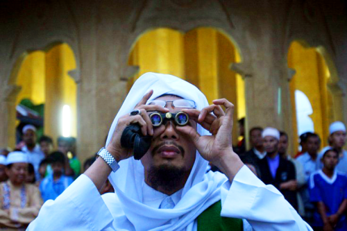 A Muslim man uses binoculars to search for the moon in Yala, Thailand.