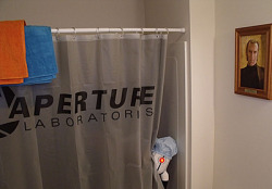 wheatleyofficial:  whatthechell:  Who’s there? [Turret Plush] [Shower Curtain] [Cave Johnson Portrait]   why is there a portrait of Cave Johnson in the bathroom 