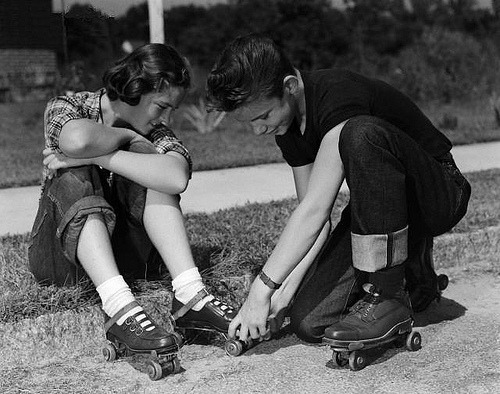 maddynorris:  A teen helping his girl put on roller skates. South Carolina, 1951.