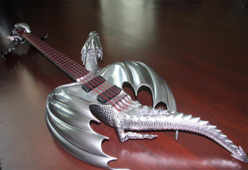 samanfuu:  ianbrooks:  Chrome Dragon Bass Guitar by Emerald Guitars Created as a commission for a client in Thailand and meant to depict a dragon in midflight, it also contains glow-y blue LED eyes and a smaller dragon on the headstock. That’s double