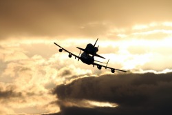 unknownskywalker:  Flying Into the Sun The Shuttle Carrier Aircraft transporting space shuttle Discovery to its new home heads into the sunrise as it departs from NASA’s Kennedy Space Center in Florida at 7 a.m. EDT. The duo headed south to fly over