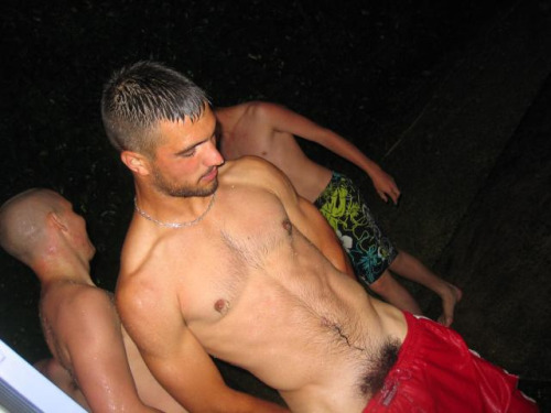 Wet hairy frat boy, pulling down his board shorts, exposing his bush. 