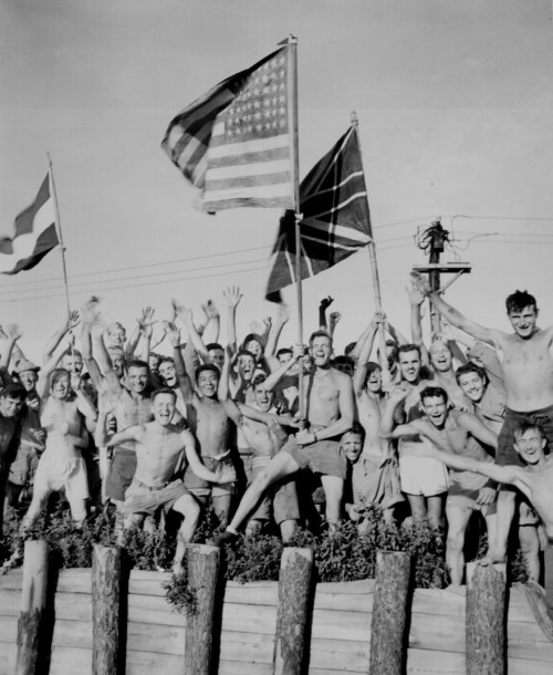 “Gaunt allied prisoners of war at Aomori camp near Yokohama cheer rescuers from U.S. Navy. Wav