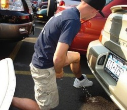 some guys piss behind cars in airport parkings