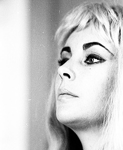 Elizabeth Taylor poses wearing a blonde wig, 1963.