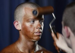 nationalpostsports:  The finishing touchesA participant has tanning lotion applied to his body during a regional bodybuilding and fitness competition in Minsk on Friday. (Photo by Vladimir Nikolsky/Reuters) 