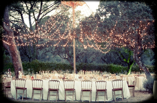 Outdoor Wedding Lighting Idea: Create a canopy of lights by hanging string lights from trees, poles,