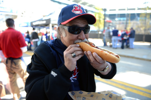 Tom Lombardo eats a foot long hotdog out side Progressive Field prior to the start of the game betwe
