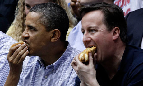 Barack Obama and David Cameron down hot dogs at a college basketball game between Mississippi Valley