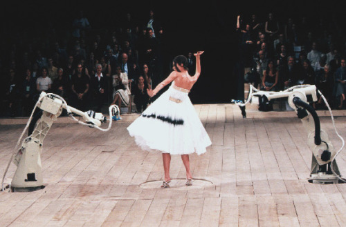 stopdropandvogue:  Shalom Harlow at Alexander McQueen Spring/Summer 1999 - No. 13  This show was inspired by the Arts and Crafts Movement and it ended with the model Shalom Harlow rotating on a turntable wearing a white dress being spray painted by two