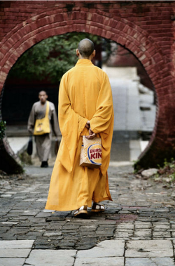 dr0gon:  A monk at the Shaolin temple in Henan Province walks with a Burger King bag. 