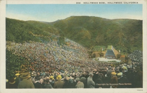 Picture postcard of the Hollywood Bowl, 1927. The shell depicted here was Lloyd Wright’s first attempt and was dismantled and replaced by his second design, an arched shell which was used for the 1928 season. The iconic current shell was added in...