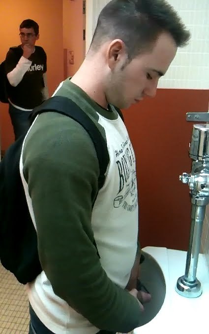 Cute college frat boy, jacking his cock at a urinal while other boys walk in.