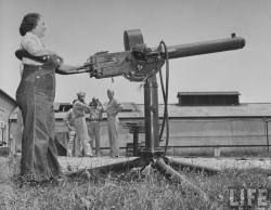 Woman firing a machine gun at Aberdeen Proving Ground, 1942. Photo by Myron Davis.