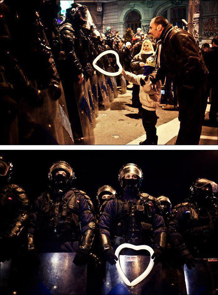flutchweg:  Romanian child hands a heart-shaped balloon to riot police during protests