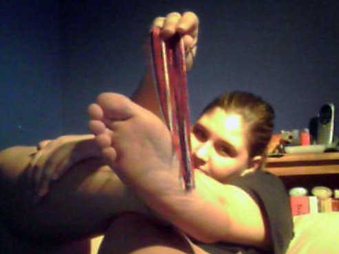 Attempting to tickle my feet with the tassel from my graduation cap.