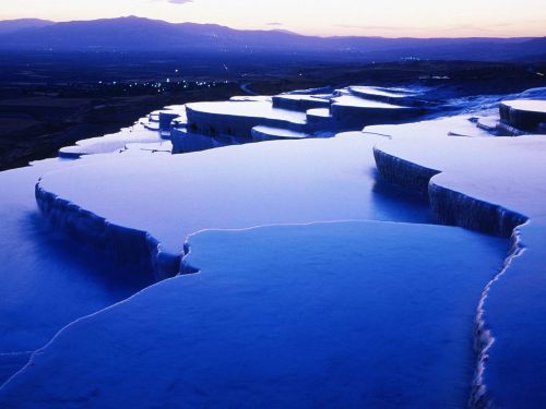     Pamukkale, Turkey, is home to hot springs that flow downhill and leave mineral deposits that bui