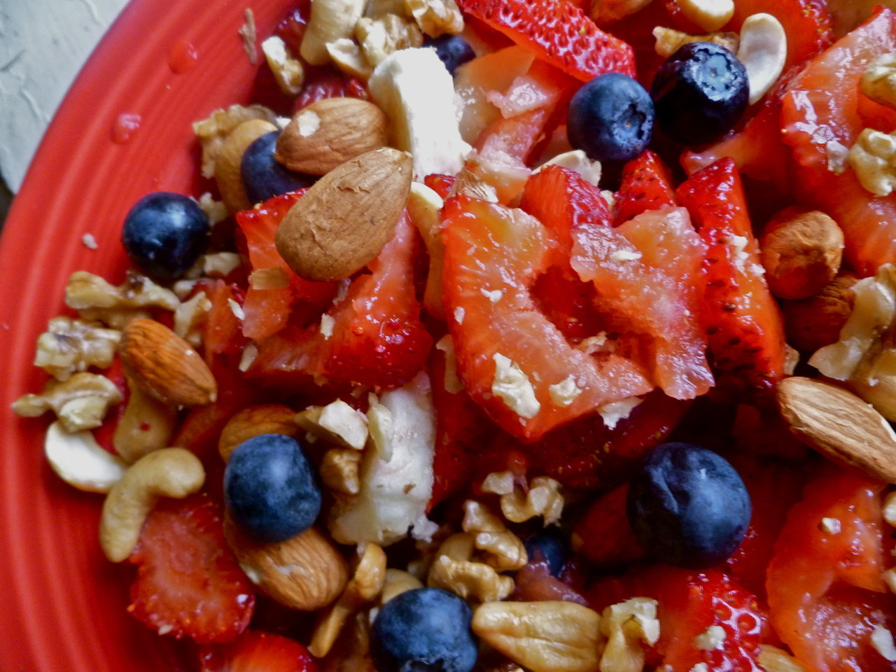 morning meals: fruit bowl consisting of strawberries, blueberries, banana, walnuts, cashews and almonds