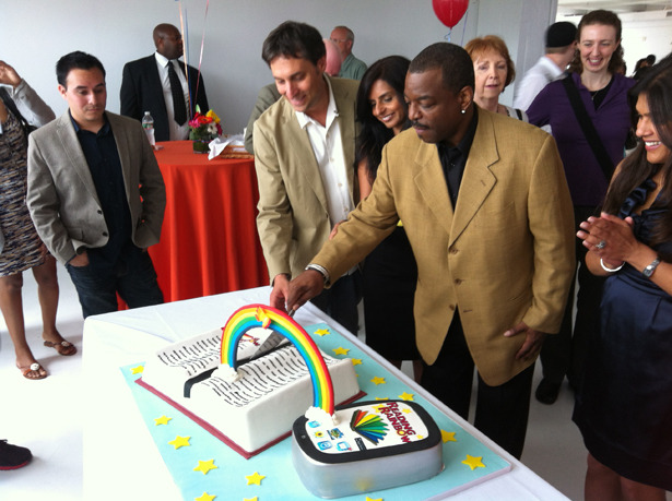 LeVar Burton cutting a slice from a Reading Rainbow cake. Burton launched a Reading Rainbow iPad app and expects to release 150 titles. We would love to know how the cake tastes. Were you there? Who got to eat the rainbow?