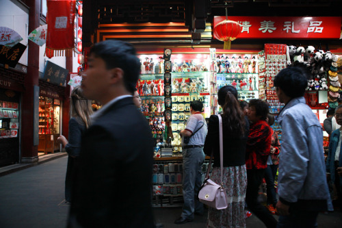 People walk by vendors selling trinkets in Shanghai’s 豫园, Yu Garden. 