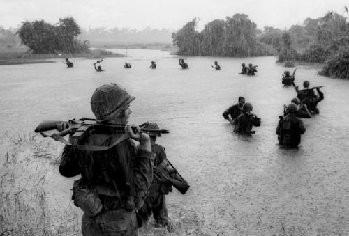 Paratroopers of the U.S. 2nd Battalion, 173rd Airborne Brigade hold their weapons above water as the