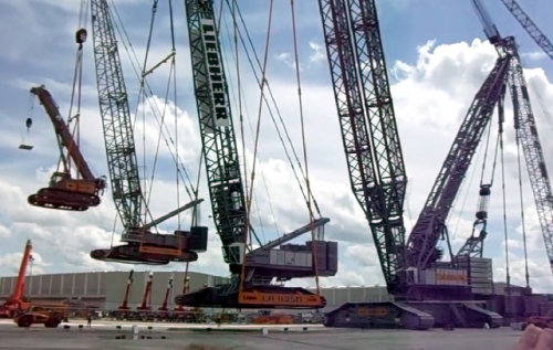 A giant crane lifting a big crane lifting a medium crane lifting a small crane lifting a model crane