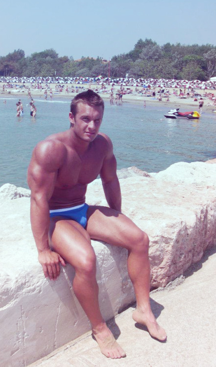 Muscled hunk on the beach in a speedo. 