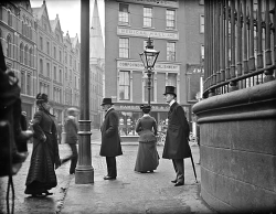 interwar:  Man with umbrella standing at the junction of Nassau Street, Grafton Street and Suffolk Street, Dublin, ca. 1900. (x) 