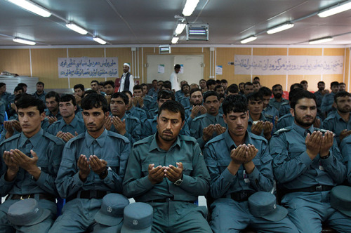 Jalalabad, Afghanistan: Newly graduated Afghan national police officers pray during a graduation cer