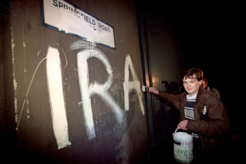 : A SUPPORTER PAINTS IRA ON THE WALL OF SPRINGFIELD ROAD POLICE STATION IN WEST BELFAST WHERE CROW