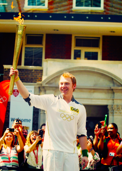  Rupert Grint holds the Olympic Flame at Middlesex University in London (July 25, 2012) 