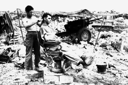 Pfc. Troy Dixon, Leadhill, Ark., uses a Japanese barber chair to cut the hair of Sgt. John Anderson,
